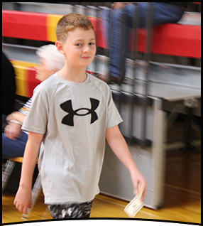 Elementary school boy walking across the gym