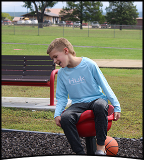 Student having fun sitting on the playground