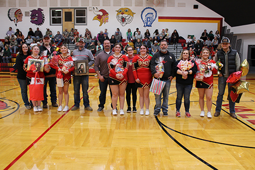 Senior cheerleaders with family members in the gym